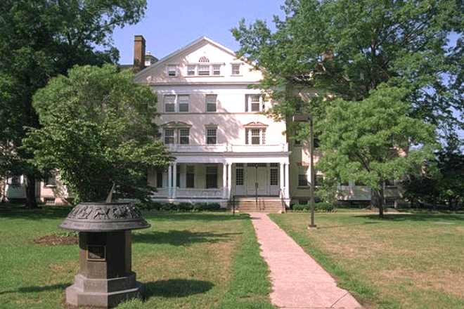 A large historic house with a large lawn