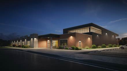 A nighttime picture of a building with wall mounted luminaires.